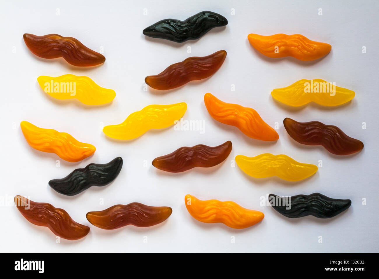 M&S dolce 'stache ribes nero, cola, limone e aroma di arancio a forma di baffi caramelle gommose spalmato su sfondo bianco Foto Stock