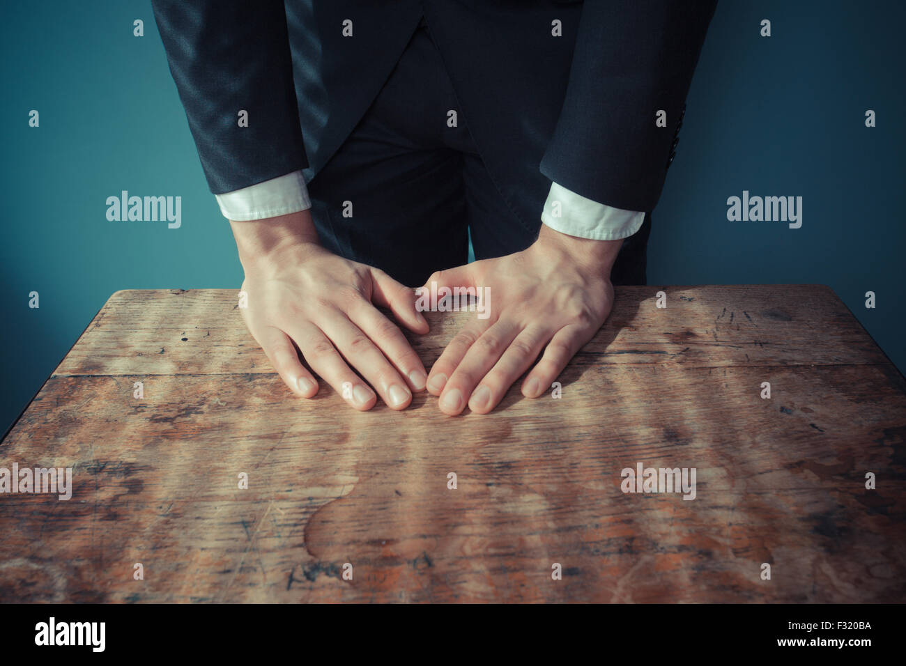 Imprenditore è in piedi e appoggiato le mani su una scrivania Foto Stock Imprenditore è in piedi e appoggiato le mani su una scrivania Foto Stock