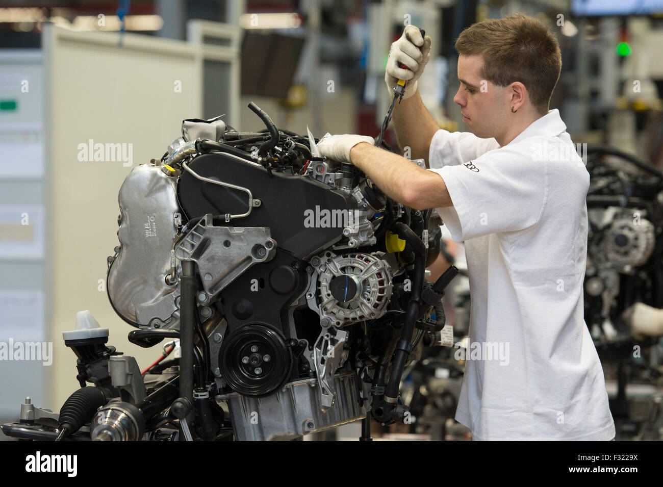 Un dipendente della Audi in fabbrica a un motore in linea di produzione a Ingolstadt, Germania, 11 marzo 2013. Foto: Armin Weigel Foto Stock