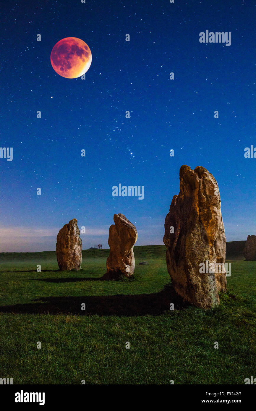 La luna di sangue oltre il sarsen le pietre a Avebury nel Wiltshire, Inghilterra, Regno Unito. Foto Stock