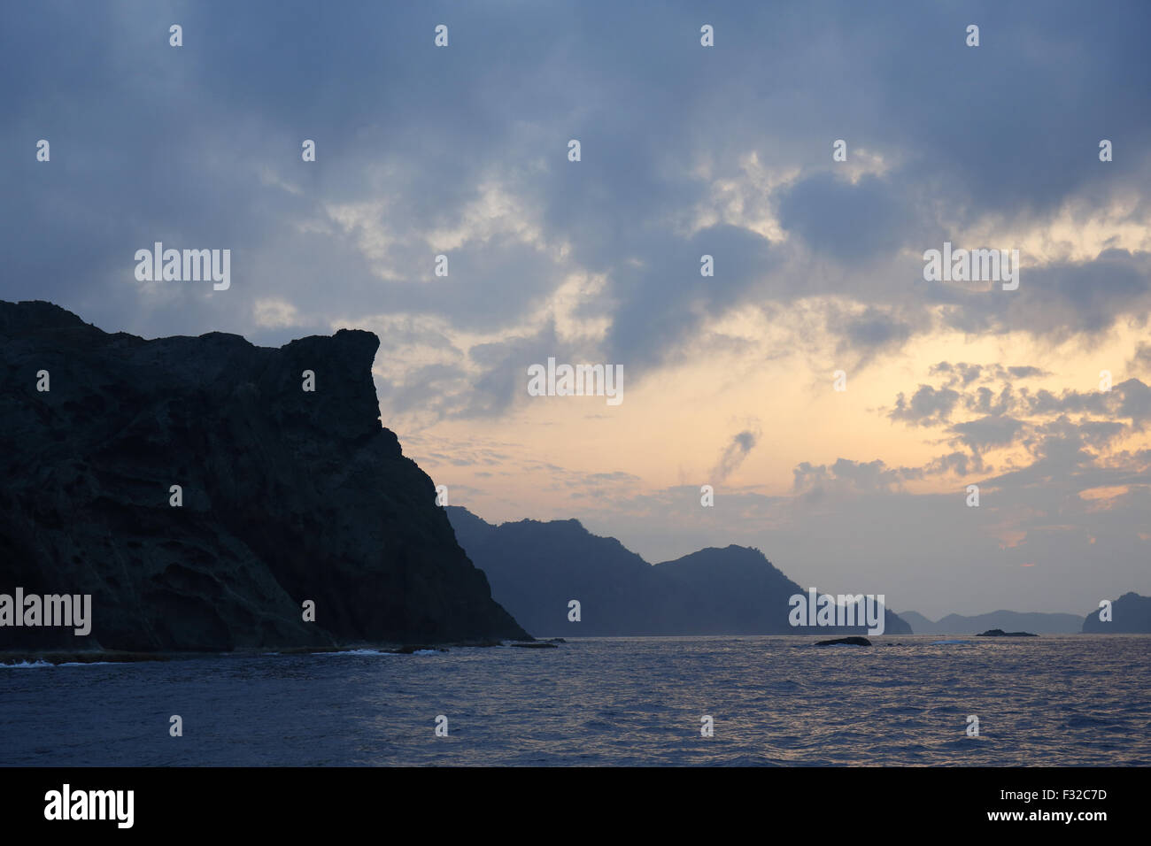 Vista delle scogliere sul mare al tramonto, Higashijima (sinistra) e Chichijima, Isole Ogasawara, Giappone, può Foto Stock