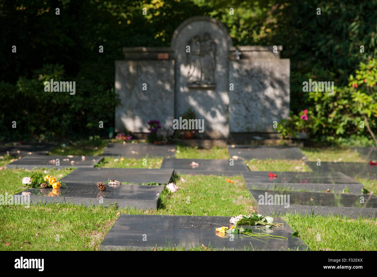 Tomba di pietra con i nomi dei morti, anonimo grave campo in erba nel cimitero di Dusseldorf-Heerdt, NRW, Germania Foto Stock