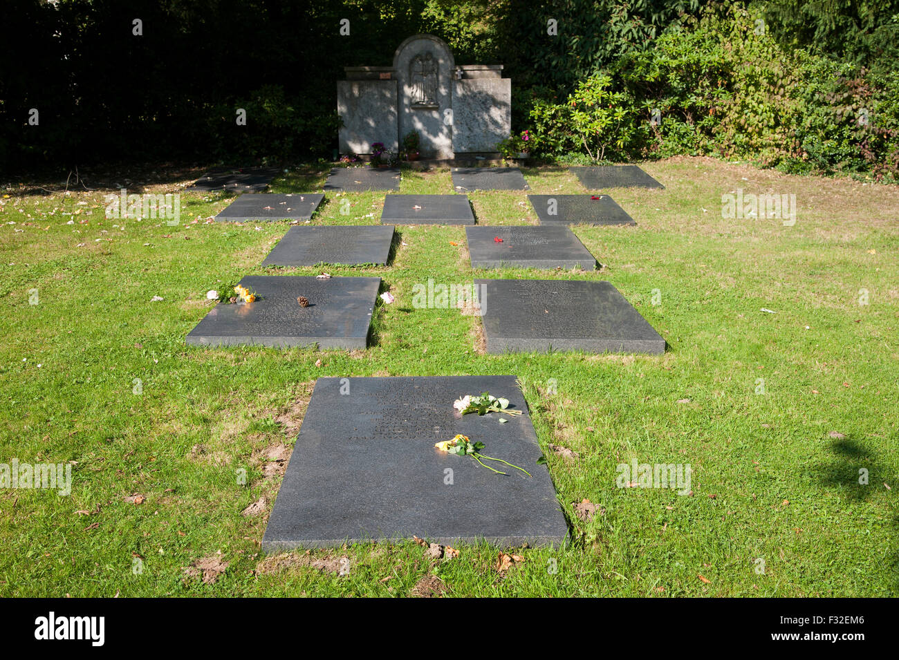 Tomba di pietra con i nomi dei morti, anonimo grave campo in erba nel cimitero di Dusseldorf-Heerdt, NRW, Germania Foto Stock