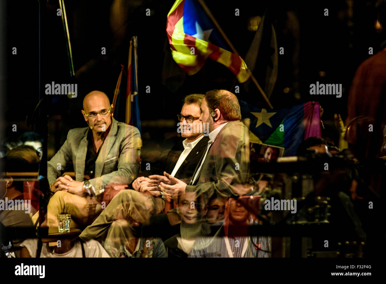 Barcellona, Spagna. Il 27 settembre, 2015. RAUL ROMEVA, ARTUR MAS e ORIOL JUNQUERAS dal pro-indipendenza cross-partito lista elettorale 'Junts pel Si' (Insieme per il sì) sono visto dietro le riflessioni in vetro come essi partecipare a un dibattito televisivo durante la notte elettorale atBarcelona partito's Mercat del Born. Credito: matthi/Alamy Live News Foto Stock