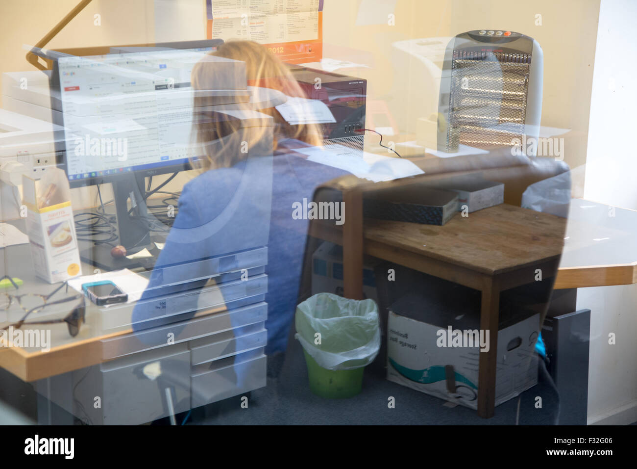 Un moman funziona su un computer in ufficio di un diritto comunitario center Foto Stock