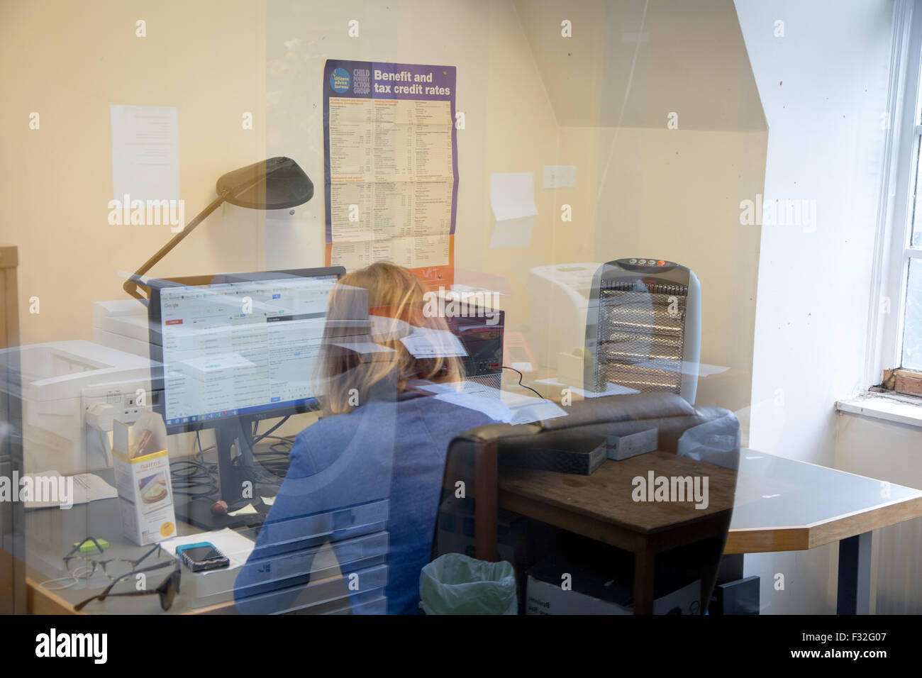 Un moman funziona su un computer in ufficio di un diritto comunitario center Foto Stock