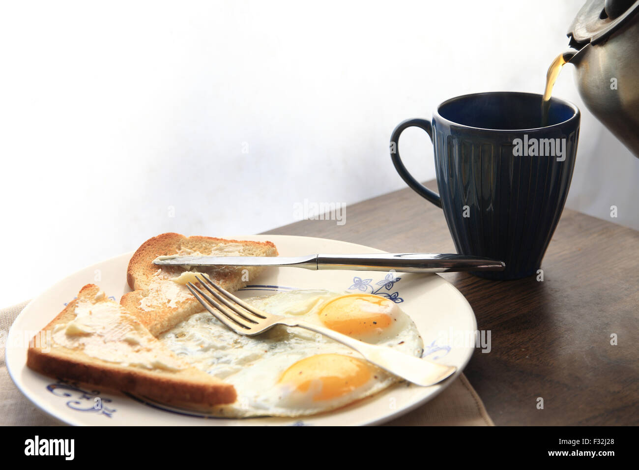 Toast imburrato, uova fritte e caffè Foto Stock