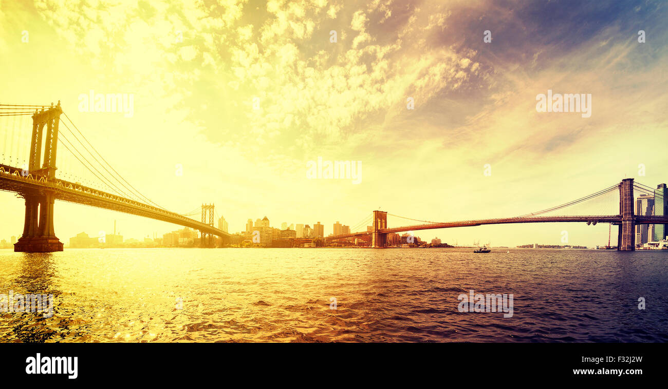 Vintage tonica drammatico tramonto su New York, panorama con il famoso Ponte di Brooklyn e Manhattan Bridge, STATI UNITI D'AMERICA. Foto Stock
