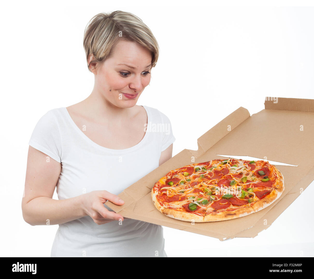 Giovane donna guardando una pizza con appetito, isolato su bianco Foto Stock