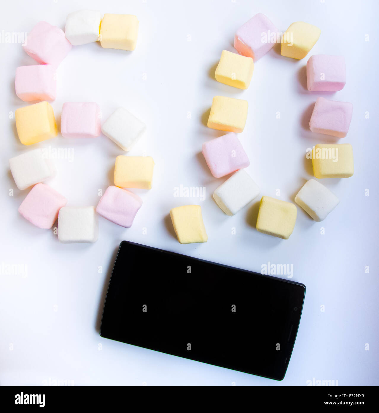 Telefono cellulare con colorato marshmallows caramelle Foto Stock