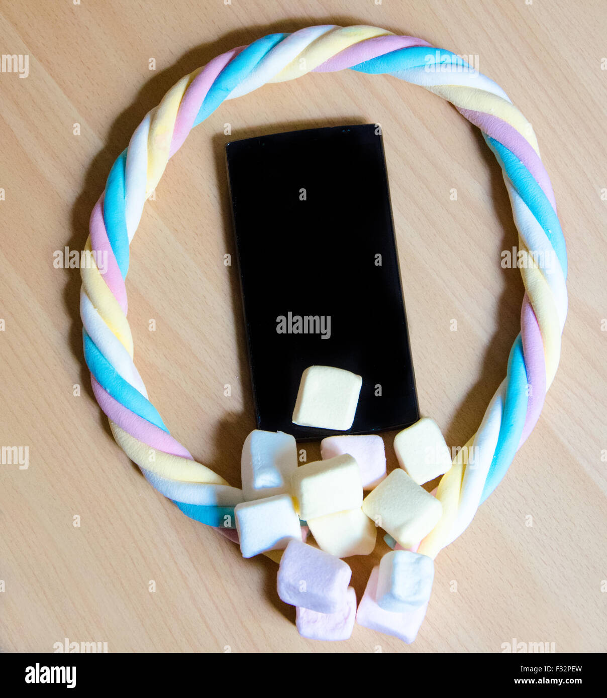 Telefono cellulare con colorato marshmallows caramelle Foto Stock