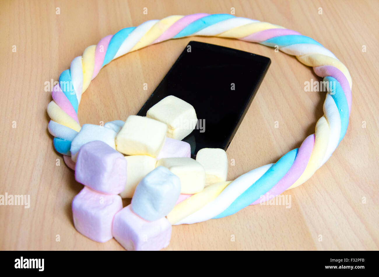 Telefono cellulare con colorato marshmallows caramelle Foto Stock