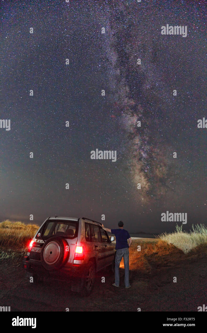 Un uomo accanto a una Mitsubishi Pajero guardando la Via Lattea Foto Stock