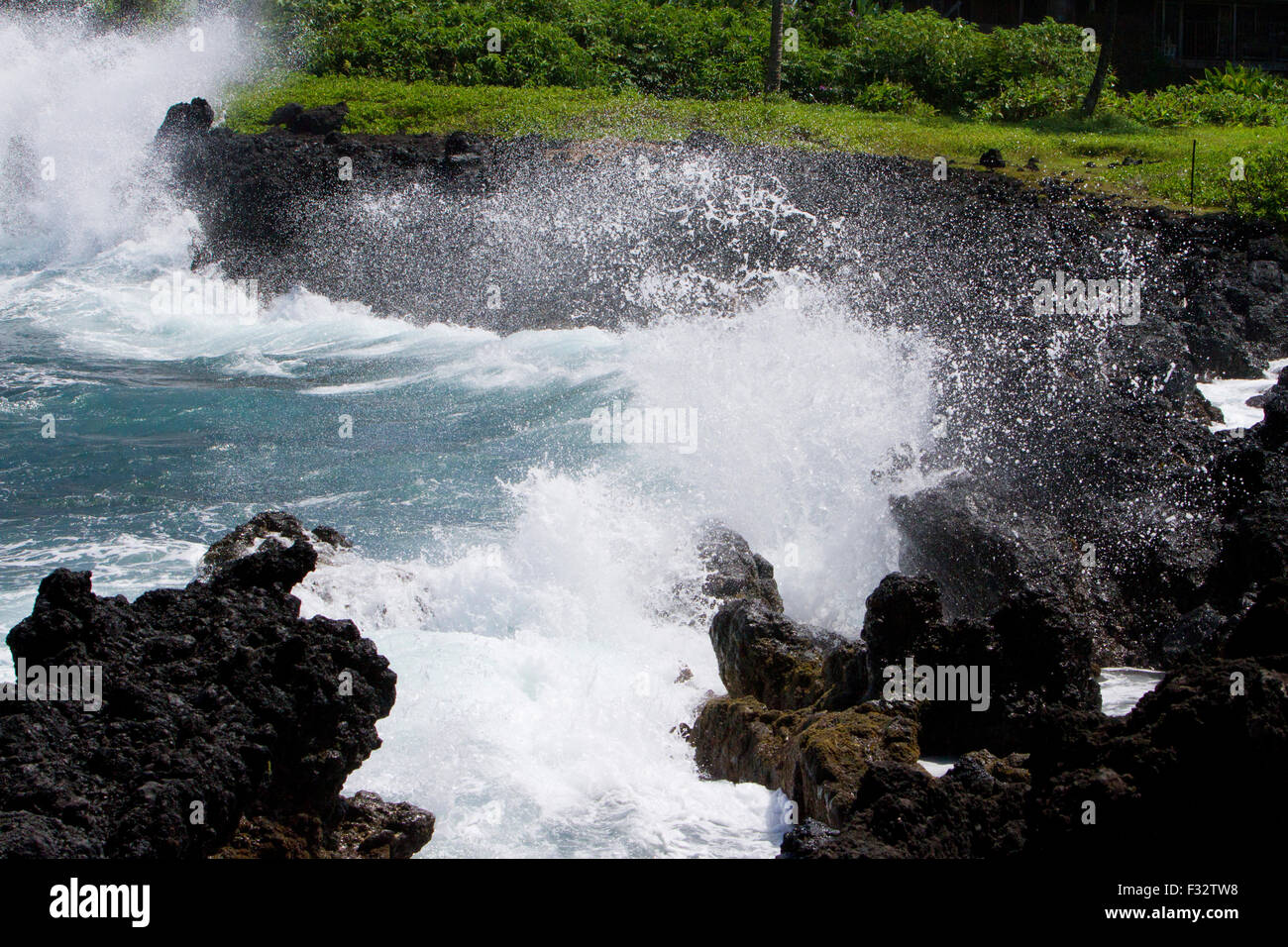Onde che si infrangono contro le rocce lungo il litorale a Penisola Keanae, appena fuori Autostrada Hana, Maui, Hawaii nel mese di agosto Foto Stock