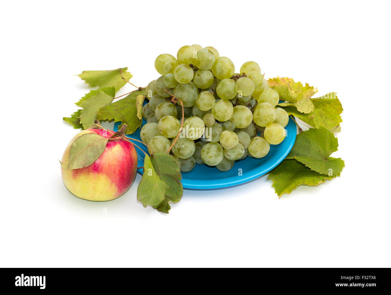 La vita ancora una piastra con uve e un Apple a sinistra, isolare Foto Stock