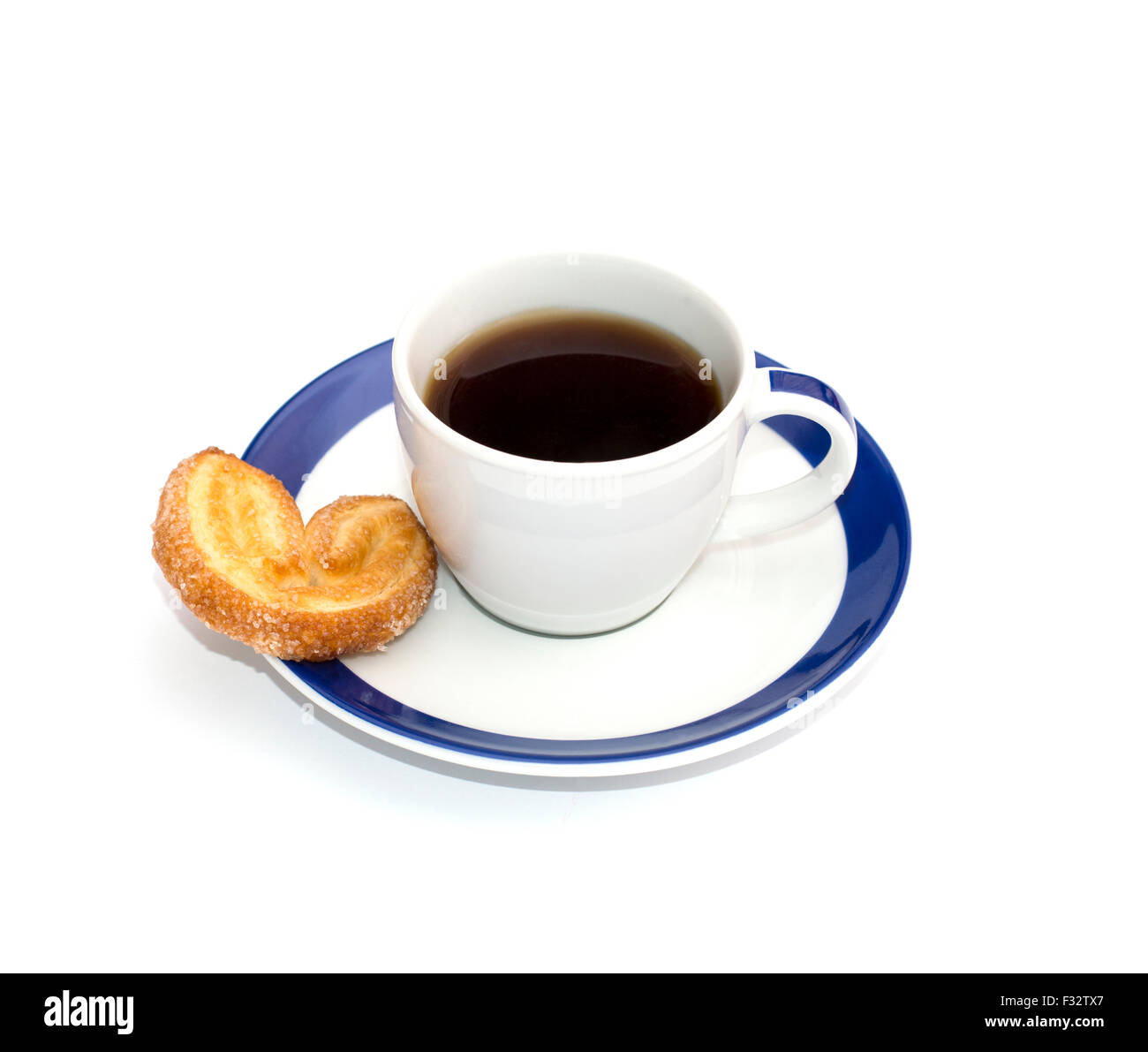 Caffè su un piattino con un bordo blu e un cookie Foto Stock