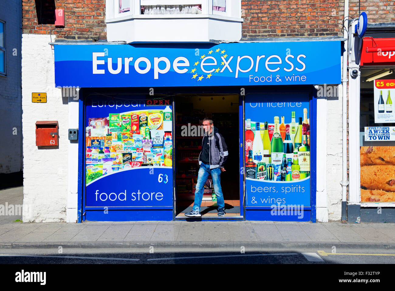 Uomo che cammina al di fuori del negozio di vendita East cibo europeo di Boston, Lincolnshire, England Regno Unito Foto Stock