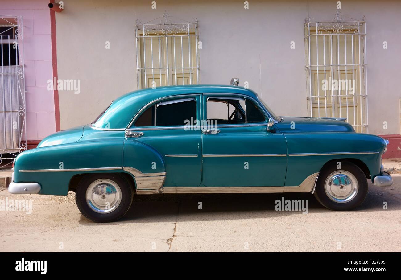 Classic American convertito in taxi di fronte ad un edificio colorato in Trinidad, Cuba. Foto Stock