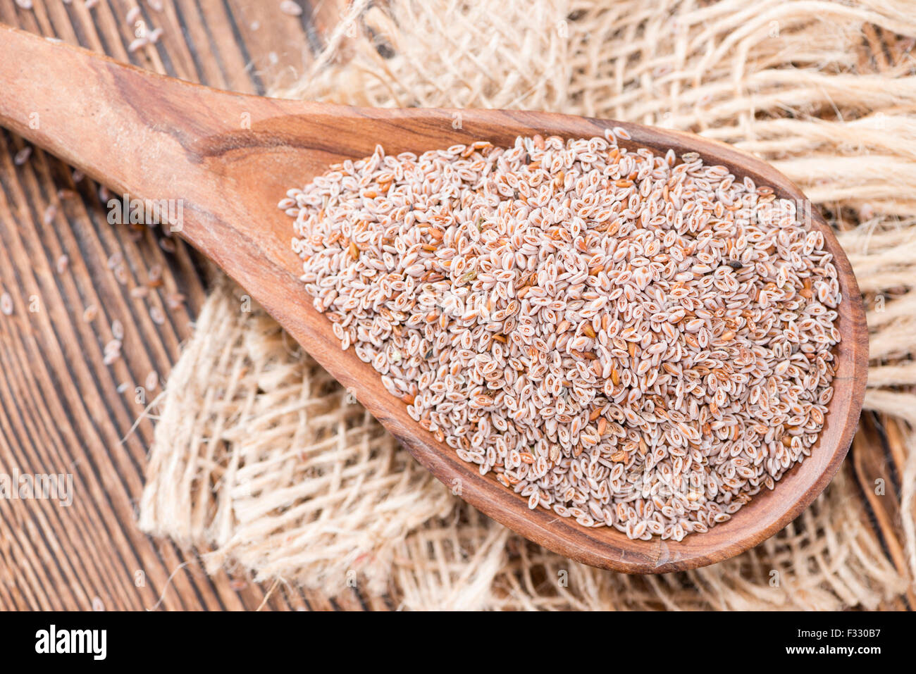 Il cucchiaio di legno con semi di psillio su sfondo scuro Foto Stock