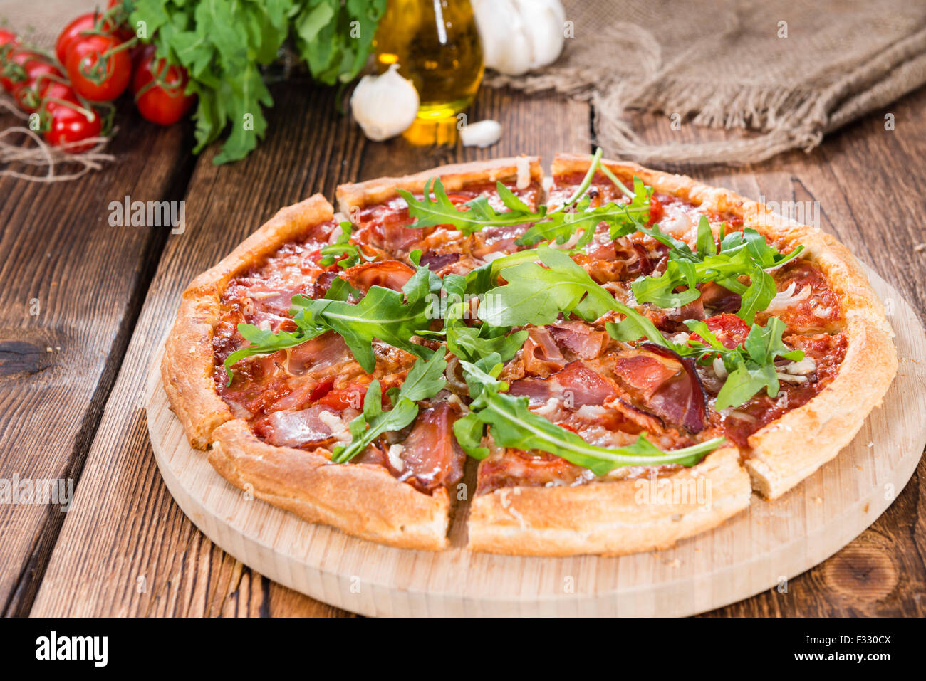 Il prosciutto casalingo fette di pizza con rucola, pomodori freschi, aglio e formaggio) Foto Stock