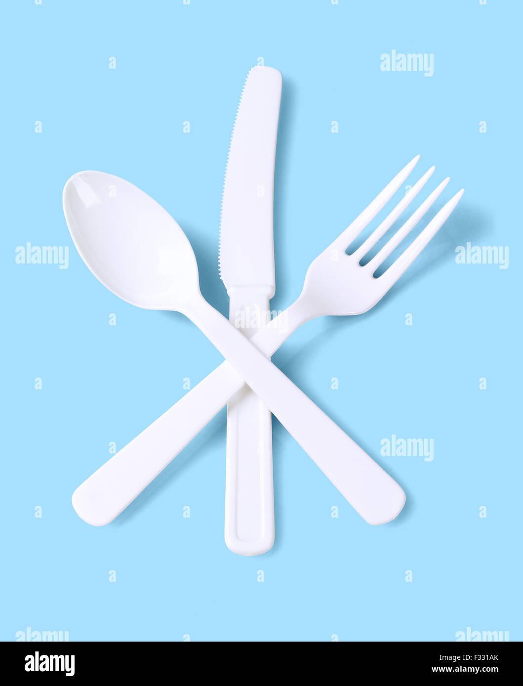 Forcella di plastica cucchiaio e coltello su sfondo blu Foto Stock