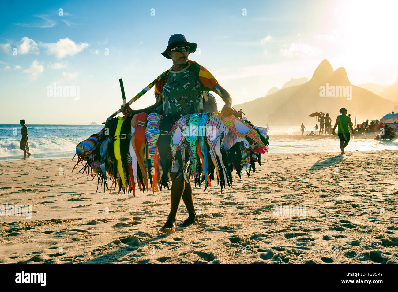 RIO DE JANEIRO, Brasile - 20 gennaio 2013: venditore a vendere bikini costume da passeggiate sulla spiaggia di Ipanema durante un tramonto nebbioso. Foto Stock