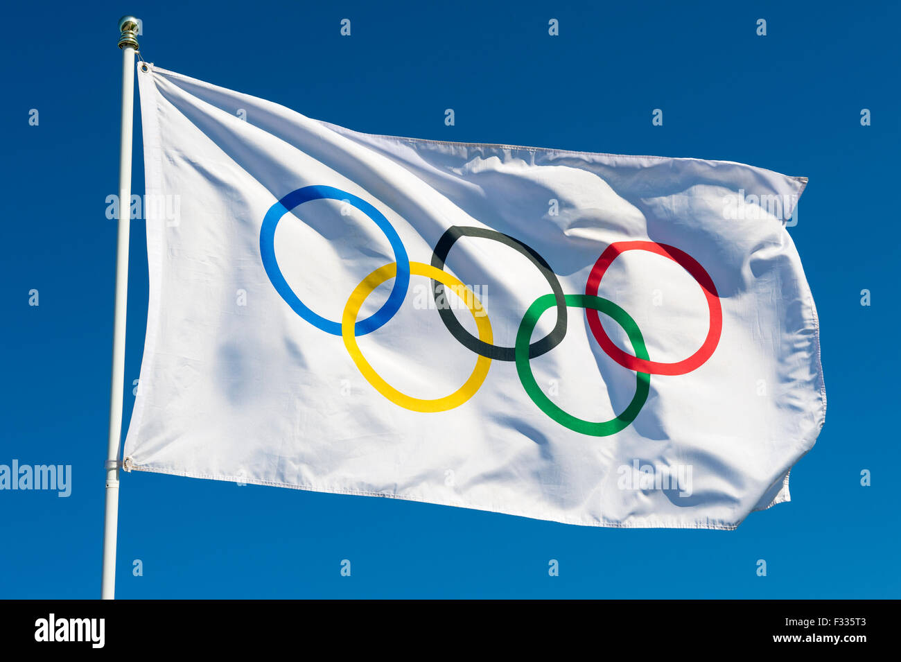 RIO DE JANEIRO, Brasile - 12 febbraio 2015: Una bandiera olimpica oscilla nel vento contro il blu intenso del cielo. Foto Stock