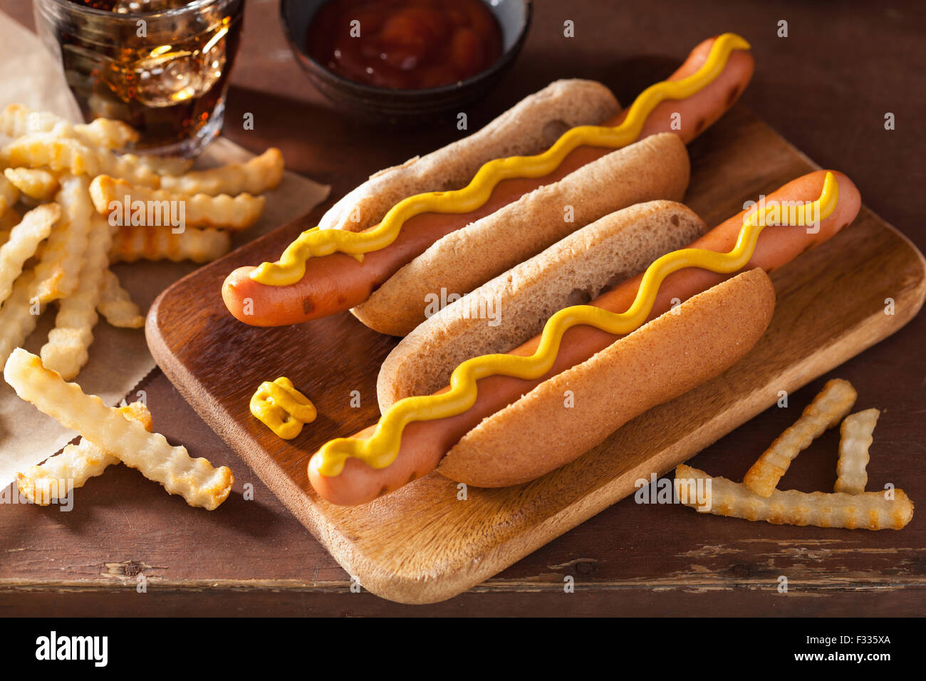 Grigliata di hot dog con senape e patatine fritte Foto Stock