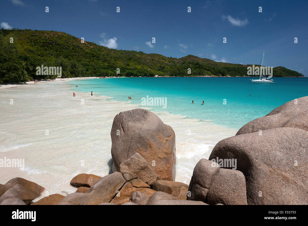 Rocce di granito, la spiaggia e la barca a vela, turchese del mare ad Anse Lazio, Isola di Praslin, Seicelle Foto Stock