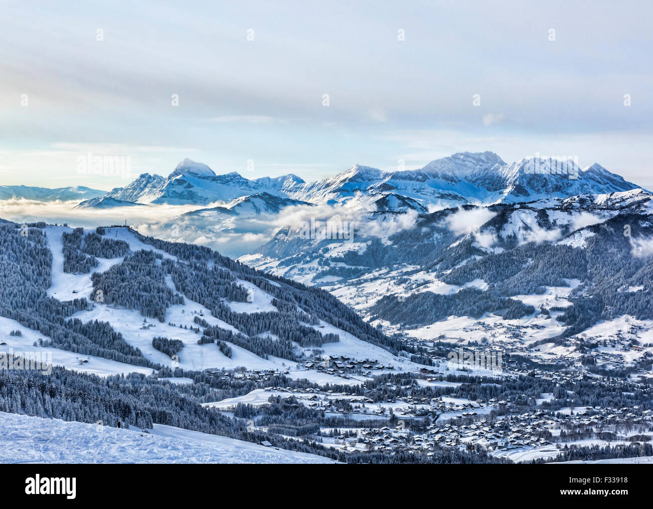 Incantevole paesaggio invernale sul massiccio del Monte Bianco con la vista della Chaine des Aravis sopra le nuvole e villaggi. Foto Stock