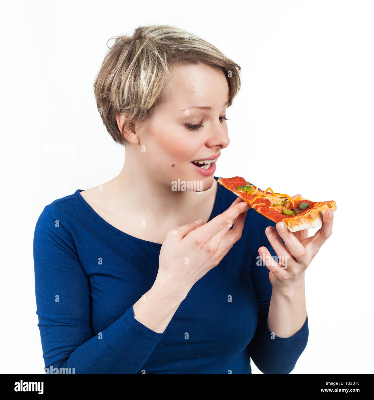 Giovane donna tenendo un trancio di pizza, isolato su bianco Foto Stock
