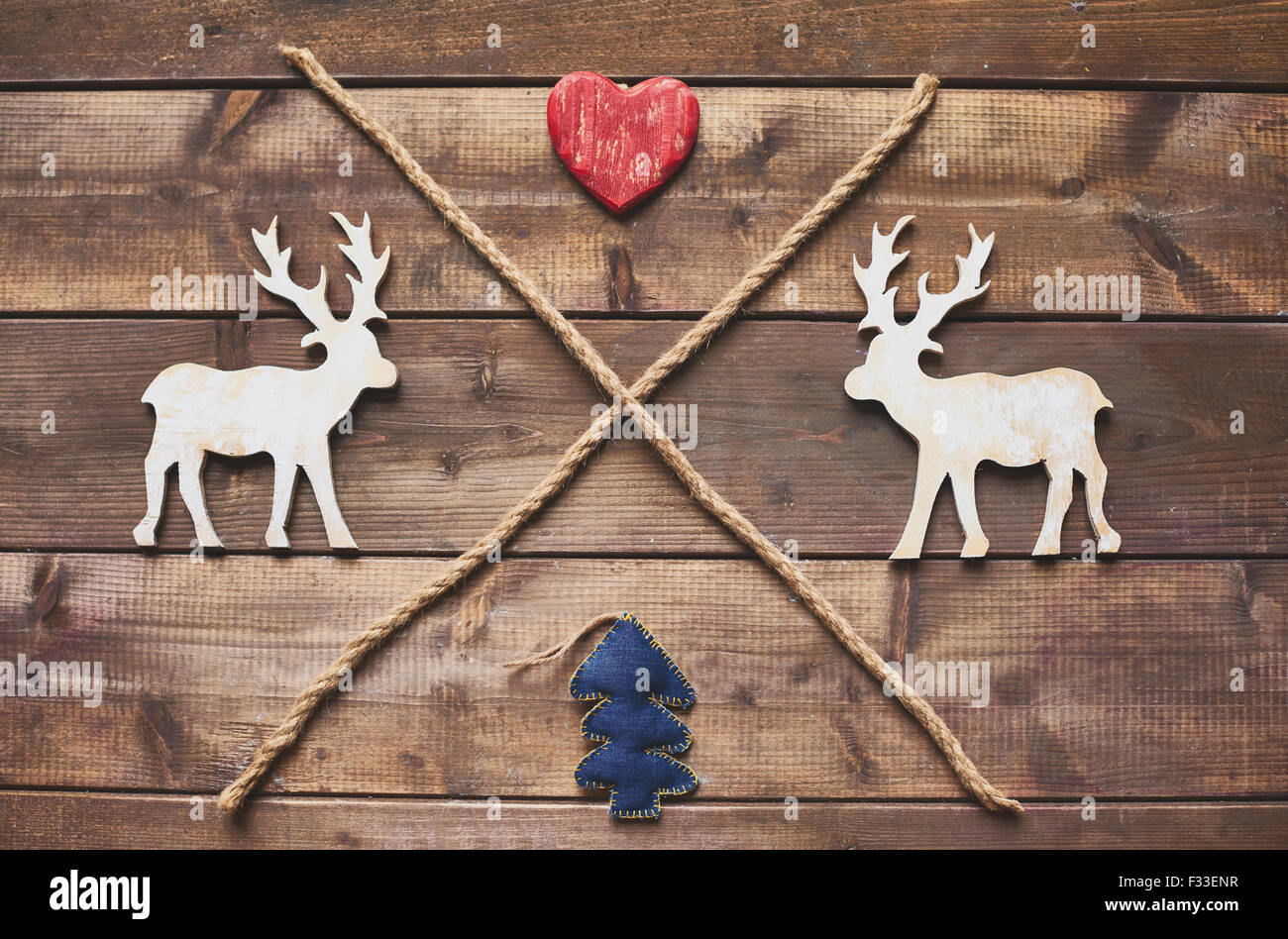 Natale in legno di cervi, cuore rosso, giocattolo abete e due funi incrociate Foto Stock
