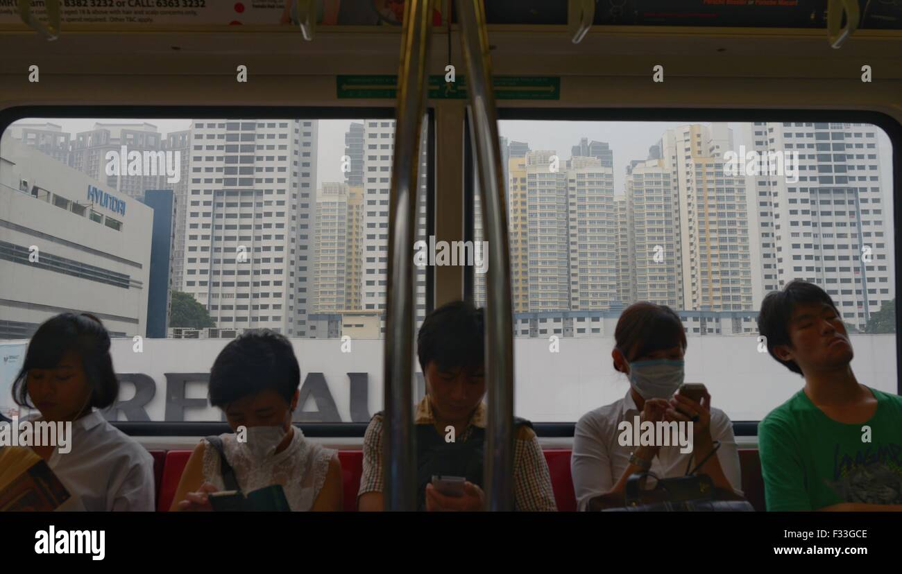 Singapore. 29Sep, 2015. I passeggeri che indossano maschere prendete la metropolitana a Singapore, Sett. 29, 2015. Le tre ore di inquinanti Indice Standard (PSI) di Singapore ha colpito 250 alle 2 del pomeriggio ora locale di martedì e raggiunto il 'molto malsana livello'. © poi Chih Wey/Xinhua/Alamy Live News Foto Stock