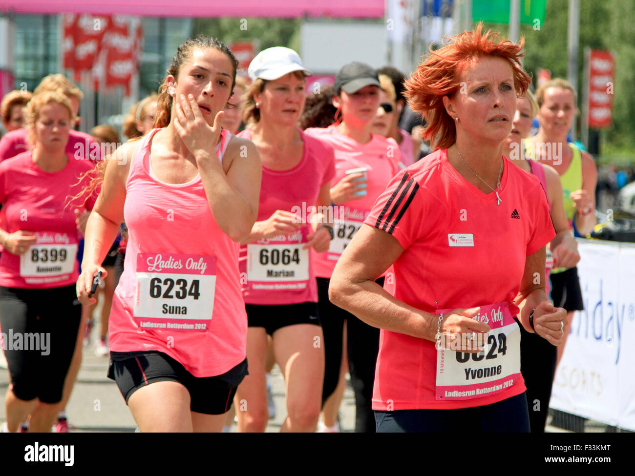 I corridori vestito in rosa eseguire passato nell'annuale Ladiesrun 10 KM evento svoltosi domenica 10 giugno 2012 a Rotterdam. Foto Stock