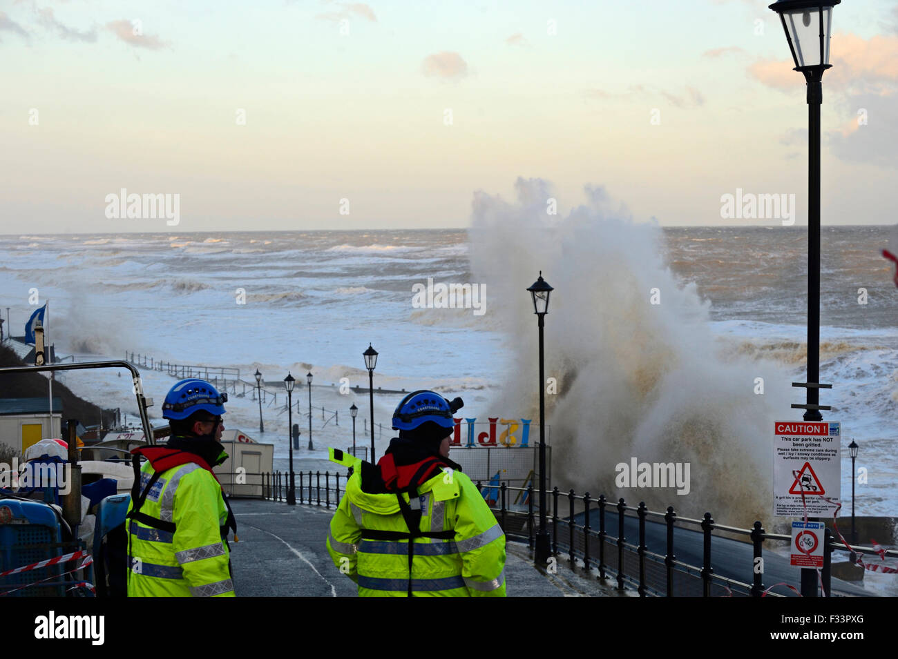I guardacoste valutare damsage lungo Cromer Promenade Norfolk all'alba dopo mareggiata Dic 2013 Foto Stock