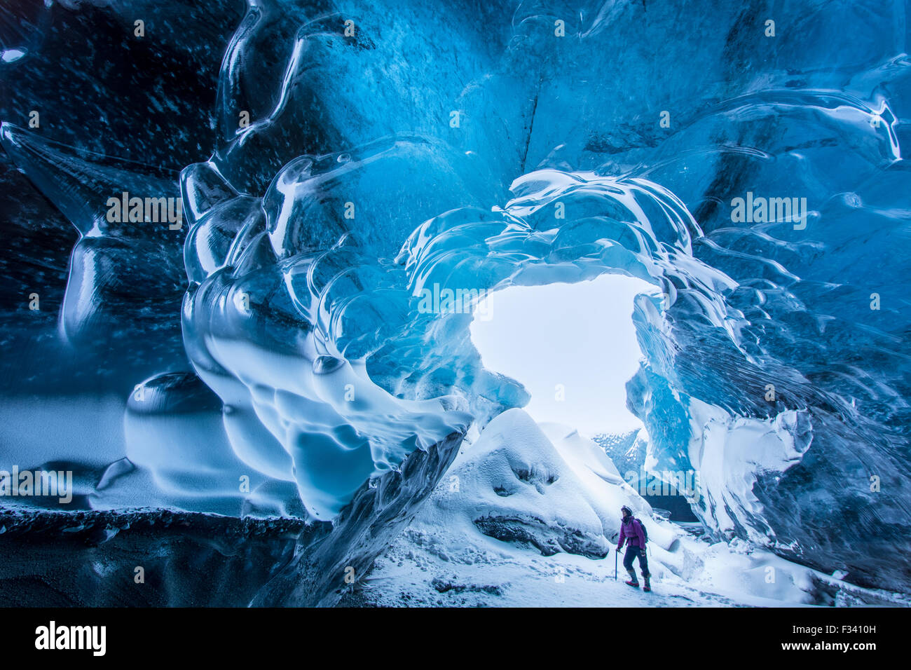 La signora Wendy Noton calcando coraggiosamente in una caverna di ghiaccio sotto il ghiacciaio Breidamerkurjokull, Islanda Orientale Foto Stock