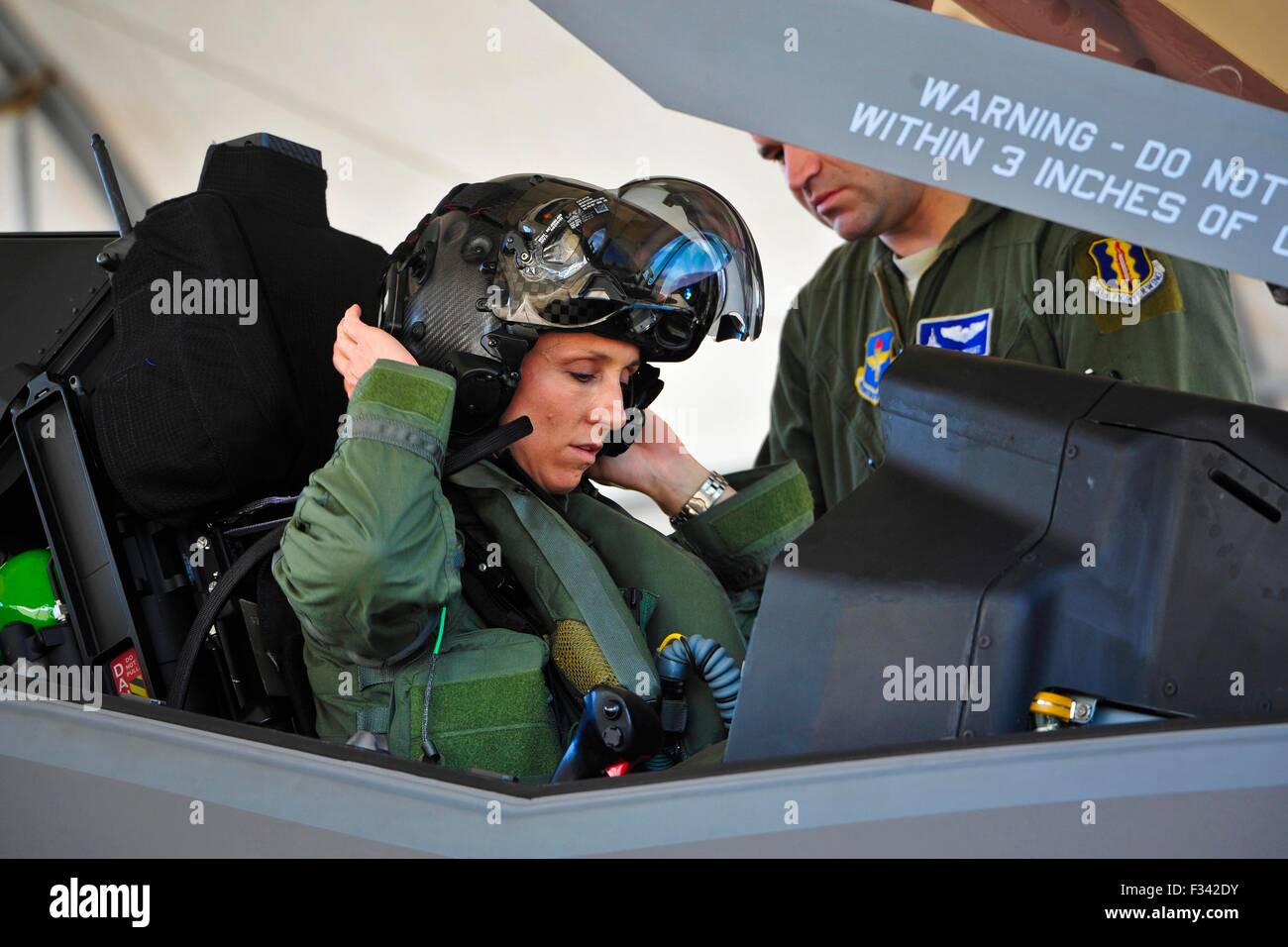 Stati Uniti Air Force Lt. Col. Christine Mau mette sul suo casco prima di prendere il suo primo volo del F-35A Stealth Fighter Aircraft Maggio 5, 2015 in Eglin Air Force Base in Florida. Mau, che precedentemente aveva volato F-15E Strike Eagles, hanno fatto la storia come la prima donna F-35 pilota in programma. Foto Stock