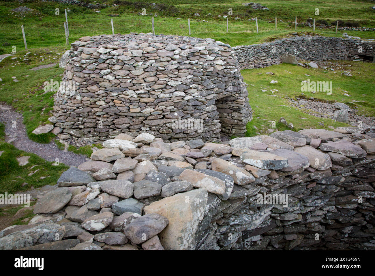 Beehive Hut o Ringfort - antiche capanne in pietra lungo la costa della penisola di Dingle, nella contea di Kerry, Repubblica di Irlanda Foto Stock