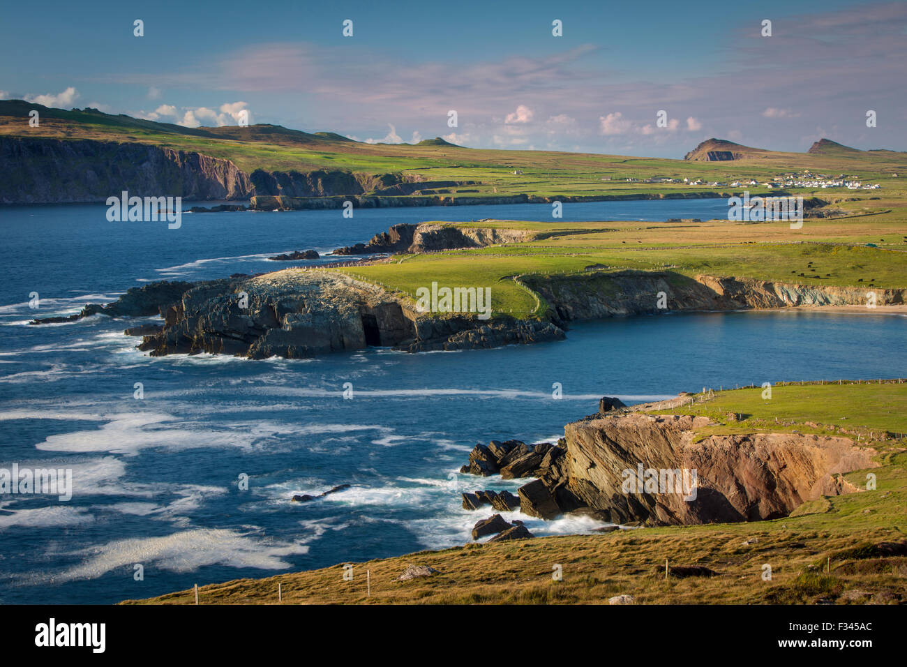 Sera La luce solare sulla baia di Ballyferriter, Sybil punto e i picchi delle Tre Sorelle, penisola di Dingle, nella contea di Kerry, Irlanda Foto Stock