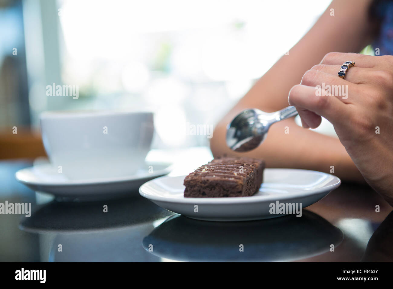 Donna di mangiare un brownie al cioccolato Foto Stock