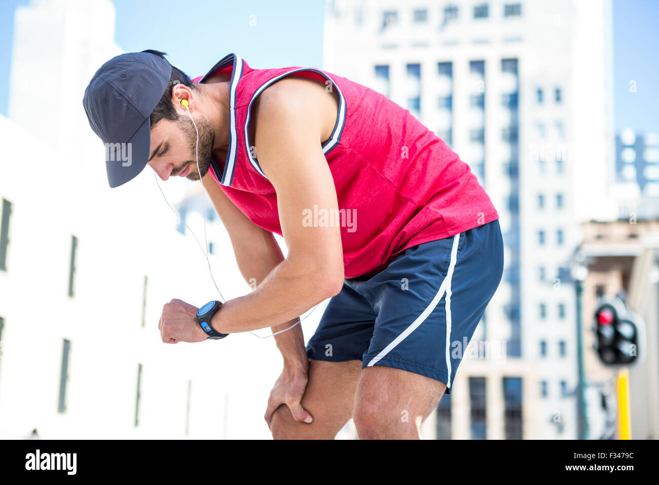 Esaurito atleta guardando al suo cronometro Foto Stock