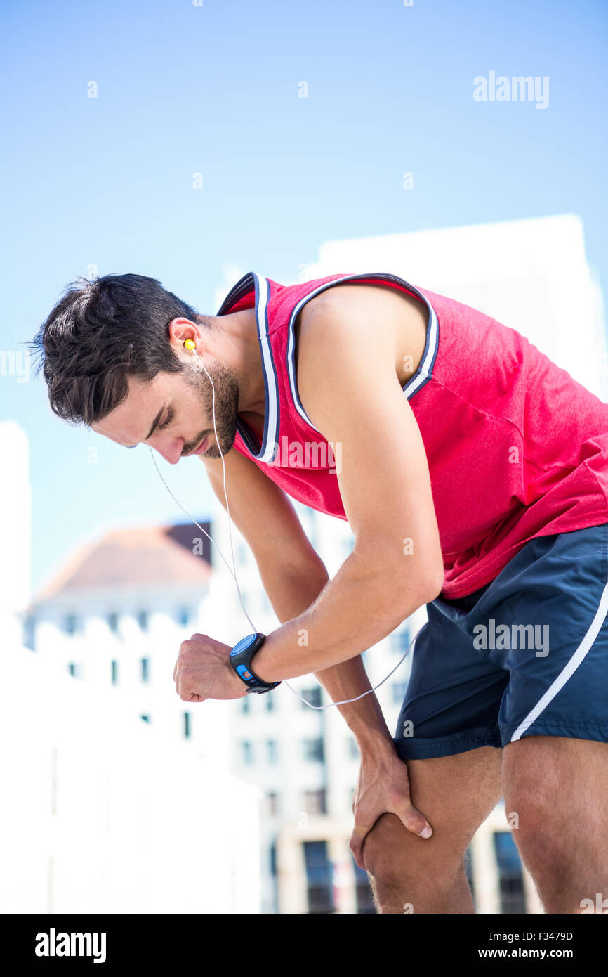 Esaurito atleta guardando al suo cronometro Foto Stock