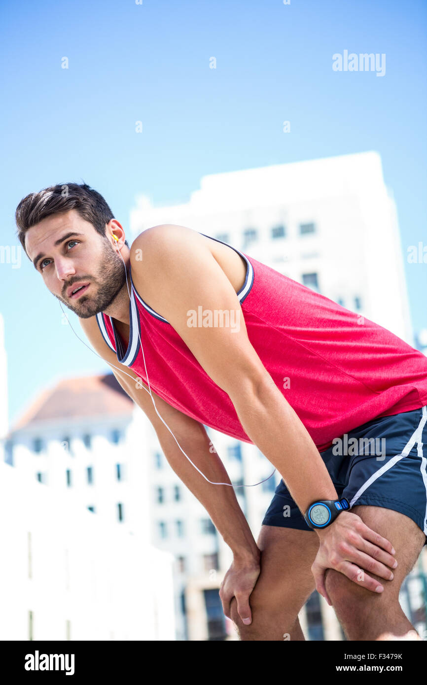 Esaurito atleta sporgersi in avanti dopo uno sforzo Foto Stock