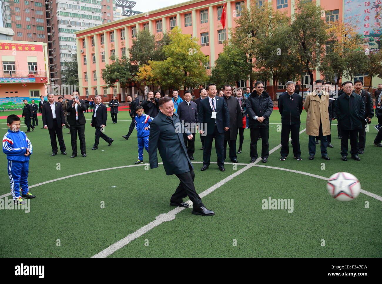 (150929) -- URUMQI, Sett. 29, 2015 (Xinhua) -- E'uigen Iminbaha, vice presidente della Cina al Congresso nazionale del popolo del comitato permanente, esegue un cerimoniale di calcio di inizio prima di iniziare una partita di calcio mentre si ispezionano i programmi sportivi a No.5 Scuola primaria in Urumqi, a nord-ovest della Cina di Xinjiang Uygur Regione autonoma, Sett. 29, 2015. (Xinhua/Ding Hai-tao) (mp) Foto Stock