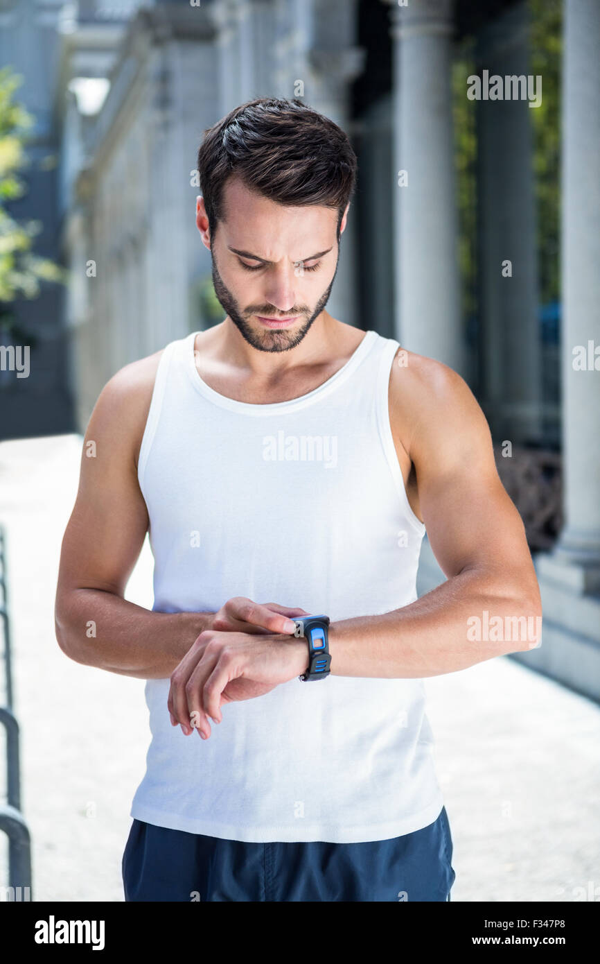 Bello concentrato atleta impostando la frequenza cardiaca watch Foto Stock