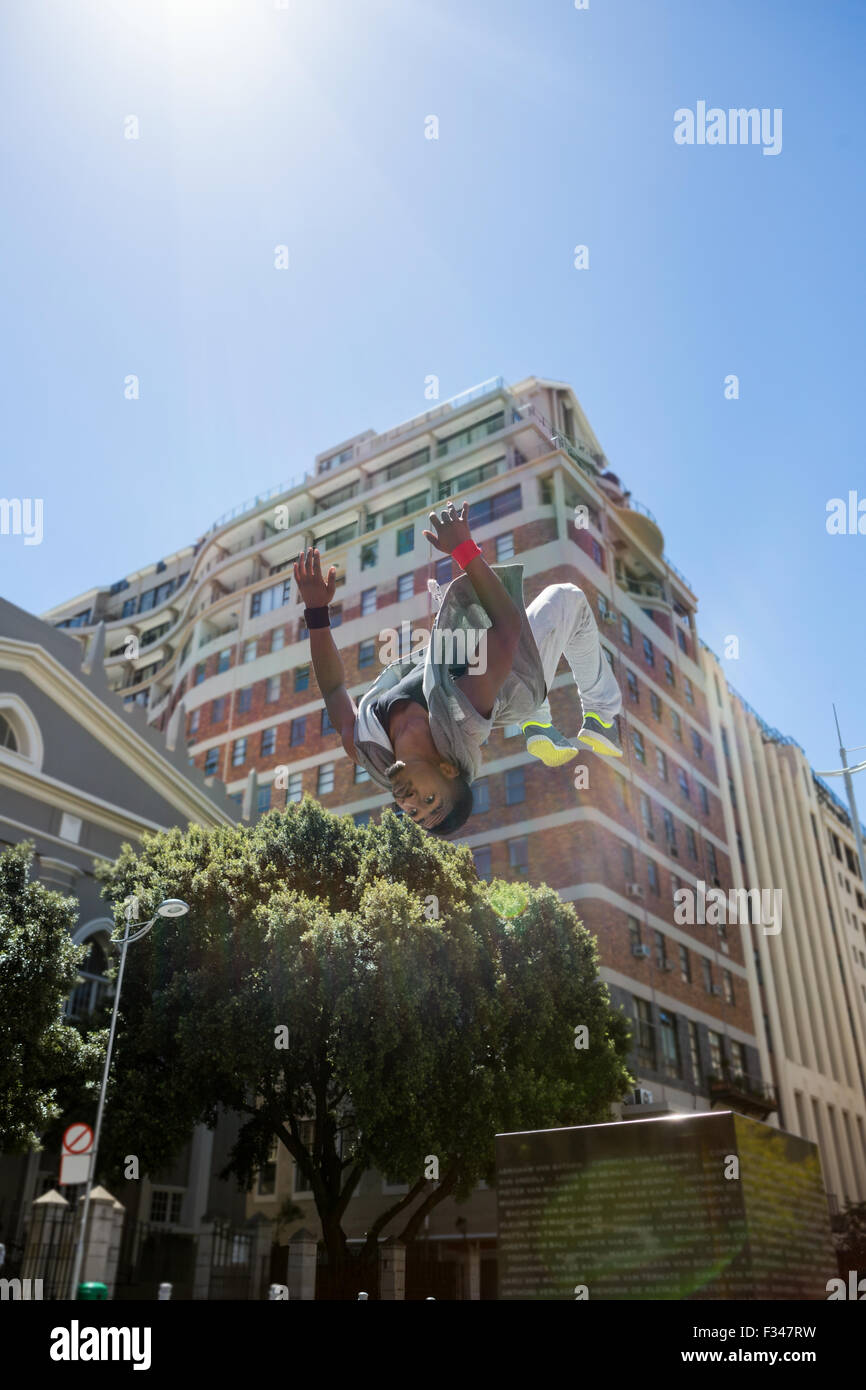 Athletic uomo fare back flip in città Foto Stock