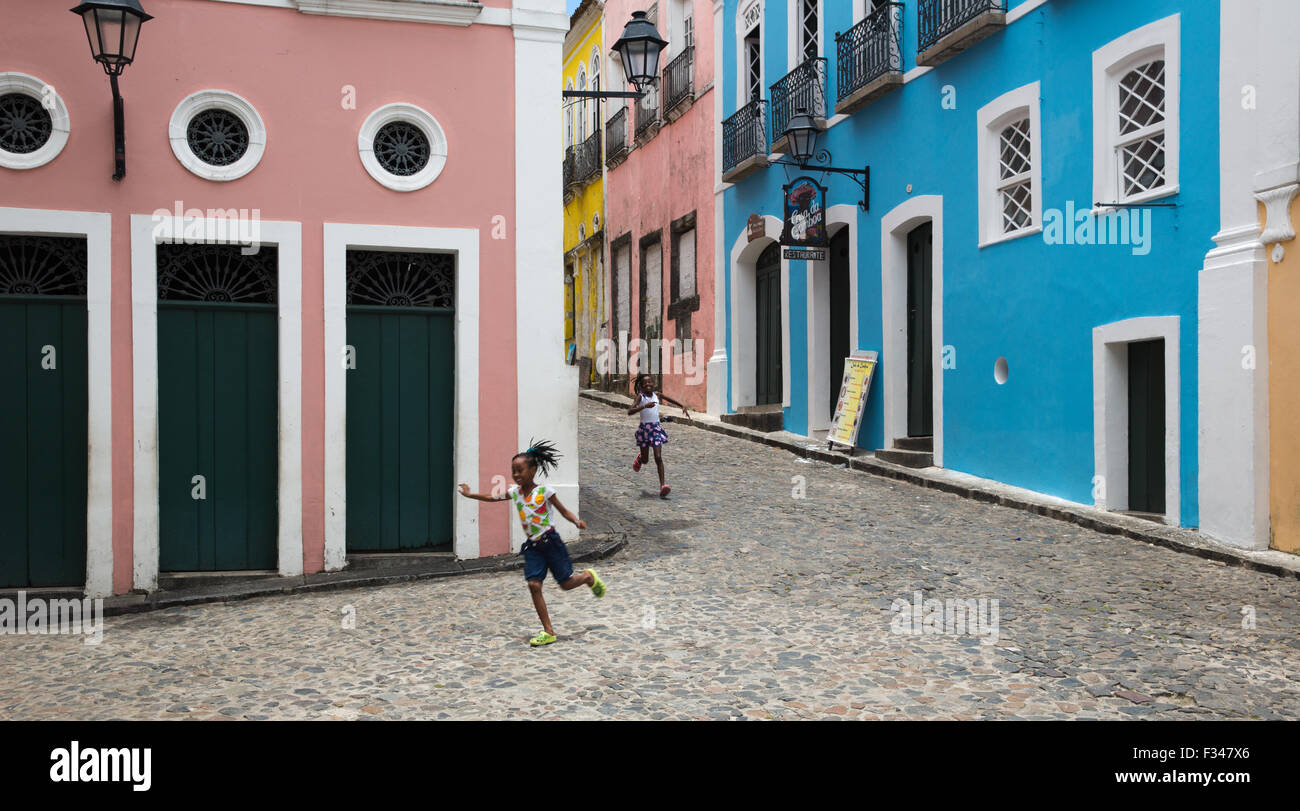 Due ragazze in esecuzione attraverso il Pelourinho nella vecchia città di Salvador, Bahia. Il Brasile Foto Stock