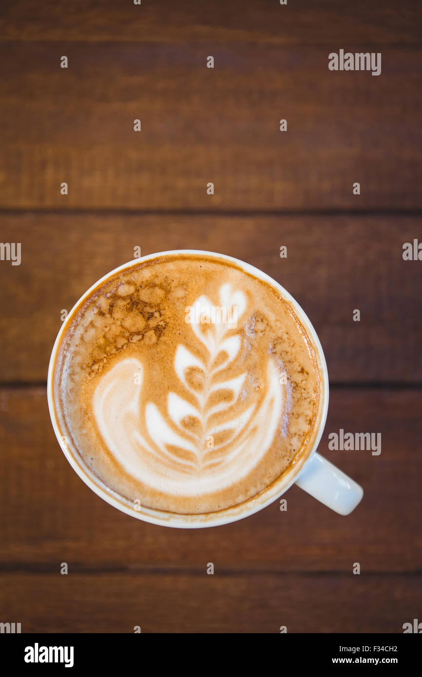Tazza di cappuccino con caffè arte sul tavolo di legno Foto Stock