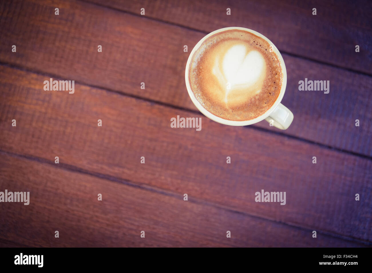 Tazza di cappuccino con caffè arte sul tavolo di legno Foto Stock