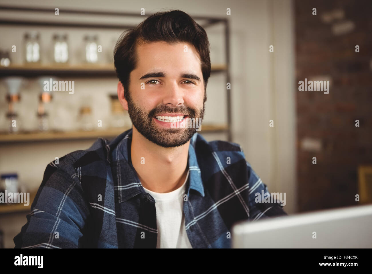 Ritratto di un uomo sorridente al lavoro sul suo computer portatile Foto Stock